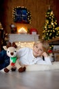 Beautiful blond child, young school boy, playing in a decorated home with knitted toys Royalty Free Stock Photo