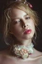 Beautiful blond fashion girl with flowers on neck and in her hair, wet Nude makeup. Beauty face. Royalty Free Stock Photo