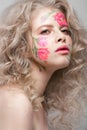 Beautiful blond girl with curls and a floral pattern on the face. Beauty flowers. Royalty Free Stock Photo