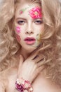 Beautiful blond girl with curls and a floral pattern on the face. Beauty flowers. Royalty Free Stock Photo