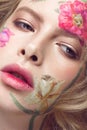 Beautiful blond girl with curls and a floral pattern on the face. Beauty flowers. Royalty Free Stock Photo