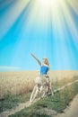 Beautiful blond girl with cycle on the wheat field Royalty Free Stock Photo