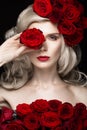 Beautiful blond girl in dress and hat with roses, classic makeup, curls, red lips. Beauty face. Royalty Free Stock Photo