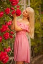 Beautiful blond girl in dress posing in summer park Royalty Free Stock Photo