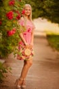 Beautiful blond girl in dress posing in summer park Royalty Free Stock Photo