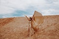 A beautiful girl in a golden with brilliant dress with wings, suit is dancing an oriental, East dance in the desert Royalty Free Stock Photo