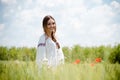 Beautiful blond girl happy smiling having fun standing in field & looking at camera on summer outdoors blue sky