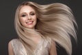 Beautiful blond girl in move with a perfectly smooth hair, and classic make-up. Beauty face. Royalty Free Stock Photo