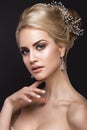 Beautiful blond girl with perfect skin, evening make-up, wedding hairstyle and accessories. Beauty face.