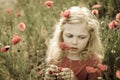 Beautiful blond girl and red poppy flowers