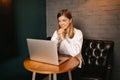 Beautiful blond girl sitting in cafe with laptop, smiling at camera Royalty Free Stock Photo