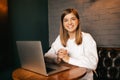 Beautiful blond girl sitting in cafe with laptop, smiling at camera Royalty Free Stock Photo