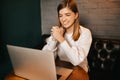 Beautiful blond girl sitting in cafe with laptop, smiling at camera Royalty Free Stock Photo