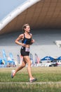 Beautiful blond girl in sport clothes running in the park