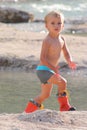 Beautiful blond hair little boy plays at the river