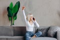 Beautiful blond happy girl is sitting on the sofa and talking on the phone Royalty Free Stock Photo