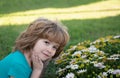 Beautiful blond little child with long hair smelling flower. Spring child face. Funny kids face. Happy little blond hair Royalty Free Stock Photo