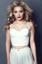 Beautiful blond model wearing white summer high waisted pants and corset strapped top Royalty Free Stock Photo