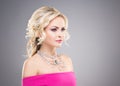 Beautiful blond in a pink dress wearing a necklace with a gem Royalty Free Stock Photo