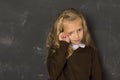 Beautiful blond schoolgirl crying sad moody and tired in front of school class blackboard