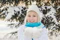 Beautiful blond smiling girl holding snow on the palms Royalty Free Stock Photo