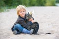 Beautiful blond toddler child with little cat on the beach, hugging, friendship between kid and kitten Royalty Free Stock Photo