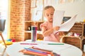 Beautiful blond toddler girl drawing with colored pencils at kindergarten Royalty Free Stock Photo