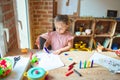 Beautiful blond toddler girl drawing with colored pencils at kindergarten Royalty Free Stock Photo