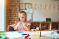 Beautiful blond toddler girl drawing with colored pencils at kindergarten Royalty Free Stock Photo