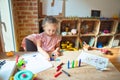 Beautiful blond toddler girl drawing with colored pencils at kindergarten Royalty Free Stock Photo