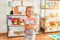 Beautiful blond toddler girl hugging cute stuffed elephant at kindergarten Royalty Free Stock Photo