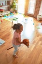 Beautiful blond toddler girl ridding horse with stick toy at kindergarten