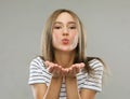 Beautiful blond woman with kiss gesture. Portrait of a flirting girl.