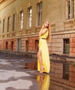 Beautiful blond woman in long yellow dress outdoors