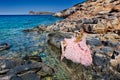 Beautiful blond woman pink ballroom dress standing on the rocks in Santorini Royalty Free Stock Photo