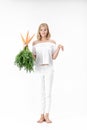 Beautiful blond woman showing rabbit and holding fresh carrot with green leaves on white background. Health and Diet Royalty Free Stock Photo