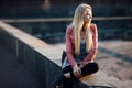 Beautiful blond woman sitting alone in the street on sunset Royalty Free Stock Photo