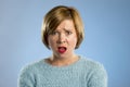 Beautiful blond woman in surprise and shock face expression expressing anxiety and fear Royalty Free Stock Photo