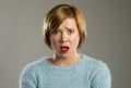 Beautiful blond woman in surprise and shock face expression expressing anxiety and fear Royalty Free Stock Photo