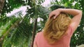 Beautiful blond woman touches her hair in nature. back view. hair treatment concept Royalty Free Stock Photo