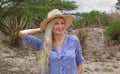 Beautiful blond woman wearing the hat outdoors in the prairie Royalty Free Stock Photo