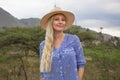 Beautiful blond woman wearing the hat outdoors in the prairie Royalty Free Stock Photo