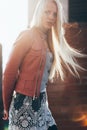 Beautiful blond woman with wind in her hair backlit by sunshine