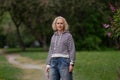 Beautiful blond women wearing casual striped hoodie and jeans walking in the park