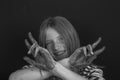 Beautiful blond young girl with freckles and hands painted in colorful paints indoors , closeup portrait, black and white Royalty Free Stock Photo