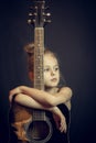 Beautiful blond young girl hug a guitar