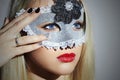 Beautiful Blond Young Woman in Carnival Mask.Masquerade. Beauty Girl with red lips. Manicure Royalty Free Stock Photo