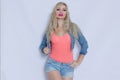 Beautiful blond young woman in pink tank top and jeans costume Royalty Free Stock Photo