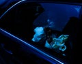 Beautiful blonde bride sitting in a stylish car with a bouquet of flowers Royalty Free Stock Photo