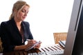 Beautiful blonde business woman with long blond hair, make-up and hairdo, wearing a dark skirt and pink blouse. Royalty Free Stock Photo